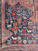 an antique qashqai rug with a blue field and small animal motifs