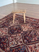 an antique shiraz qashqai rug with a navy blue field and red accents