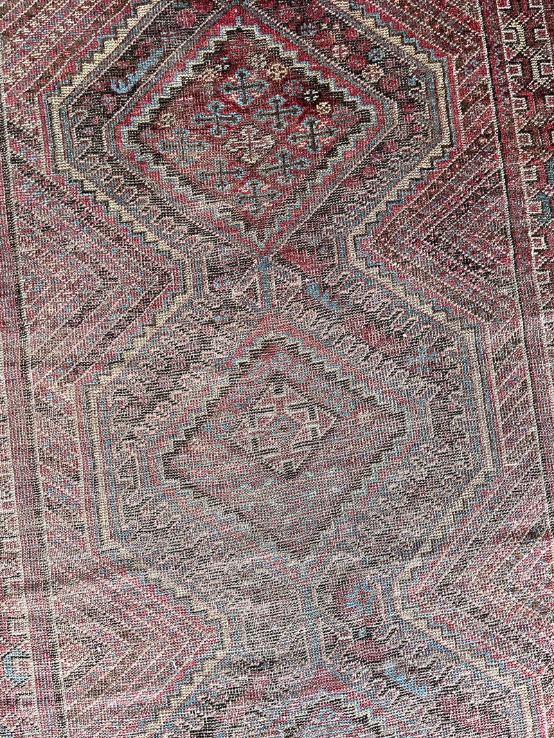 an antique shiraz rug with a unique stripe pattern in pretty primary colors