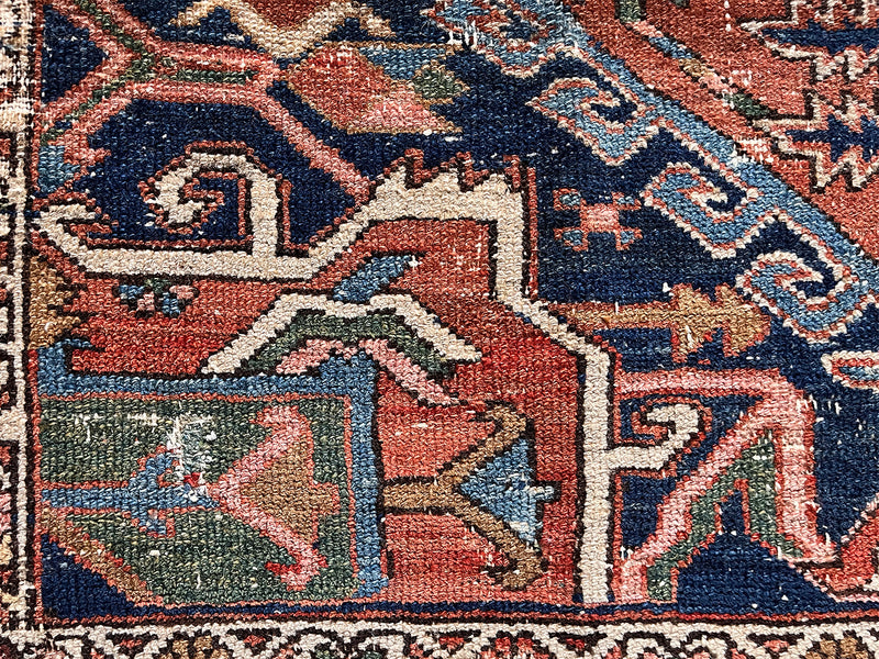 a mini antique heriz rug with a pretty rust field and dark blue, green and salmon pink accents
