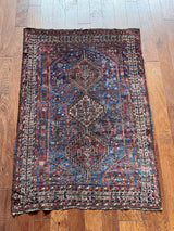 a medium antique shiraz rug with a royal blue field and coral accents