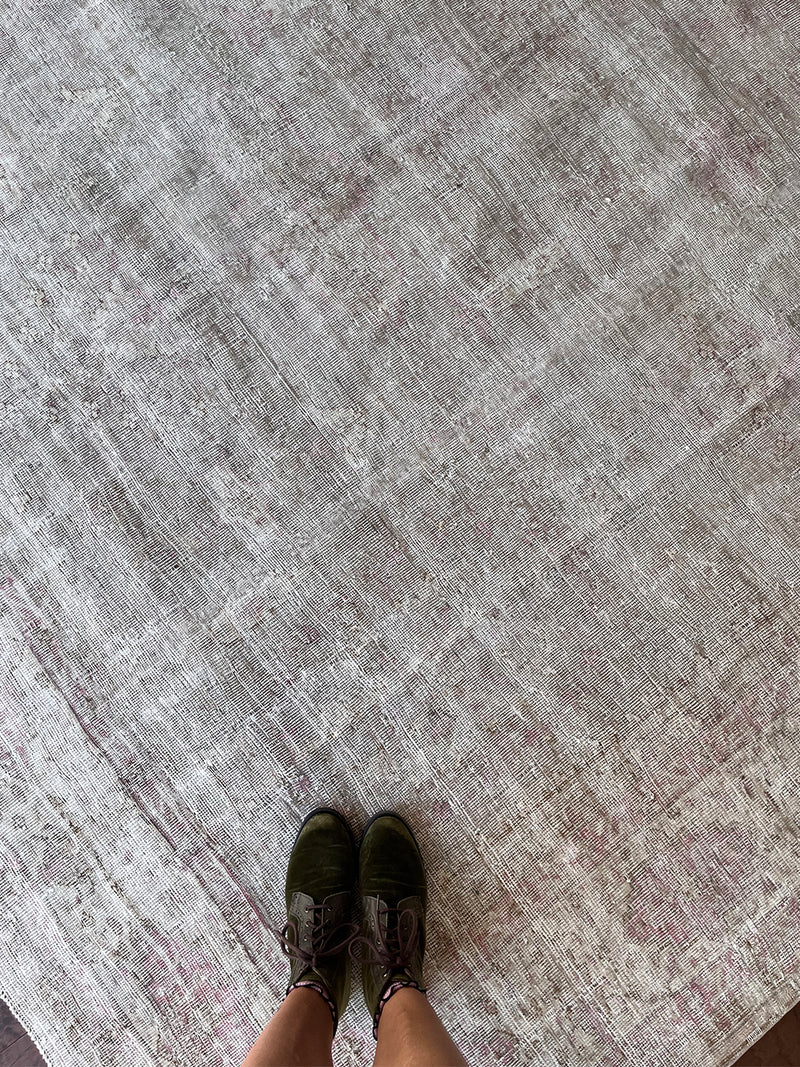a large faded oushak rug with a soft dusty pink palette and fawn details