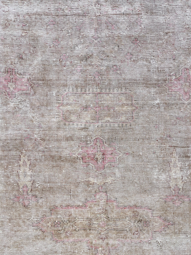 a large faded oushak rug with a soft dusty pink palette and fawn details