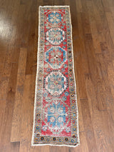 an antique heriz runner with a red field and royal blue medallions