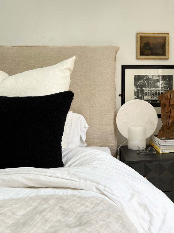 a black velvet pillow in shearling with a plush velvet backing and exposed brass zipper