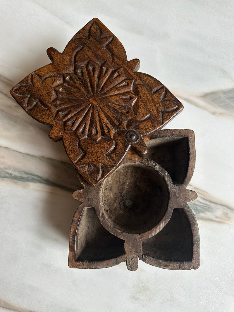 a pretty carved indian spice box with a twisting lid 
