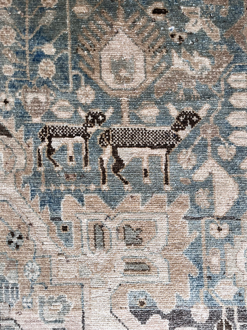 a vintage malayer rug with a teal field and detailed deer motifs 