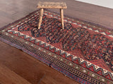 an antique qashqai rug with a dark blue field and bird pattern