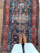 an antique malayer runner with a prussian blue field and a red floral border