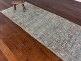 an antique mahal rug with a teal field and a brown paisley pattern