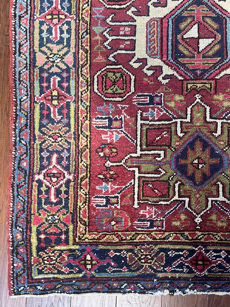 a vintage heriz karajah rug with a ref field and lime green medallions