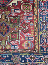 a vintage heriz karajah rug with a ref field and lime green medallions