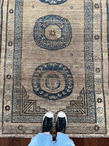 an antique khotan rug with a camel field and a border border and central medallions