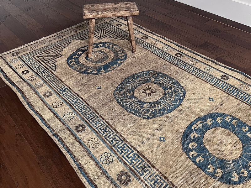 an antique khotan rug with a camel field and a border border and central medallions