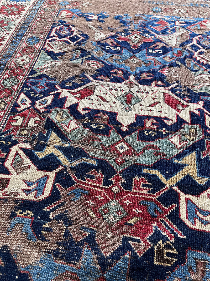 an antique caucasian shirwan rug with a royal blue field and brick red accents