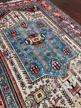 a vintage malayer rug with a neutral field, electric blue medallion and pink and lemon yellow accents
