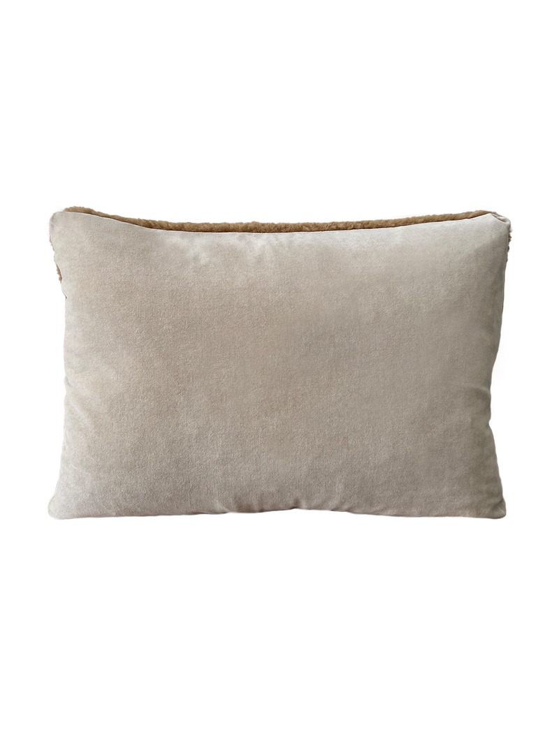a shearling pillow in camel with a velvet backing and exposed brass zipper