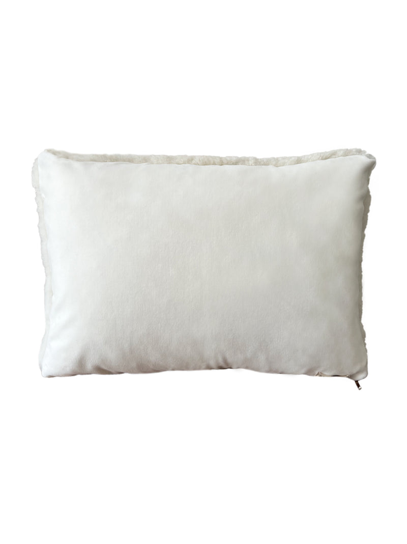 a cream lumbar pillow in shearling, backed with plush velvet
