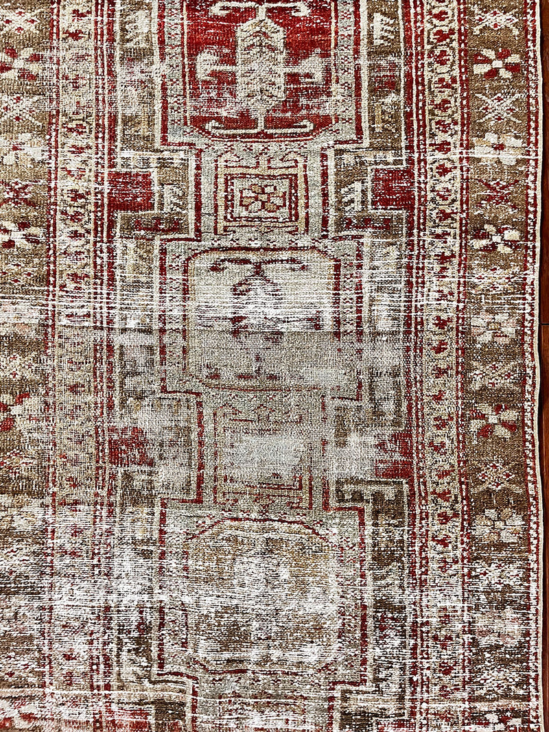 a beautiful antique heriz karajah runner with a brown and brick red palette and lemon yellow accents