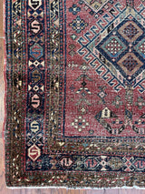 an antique heriz rug with a raspberry pink field and three pretty central medallions