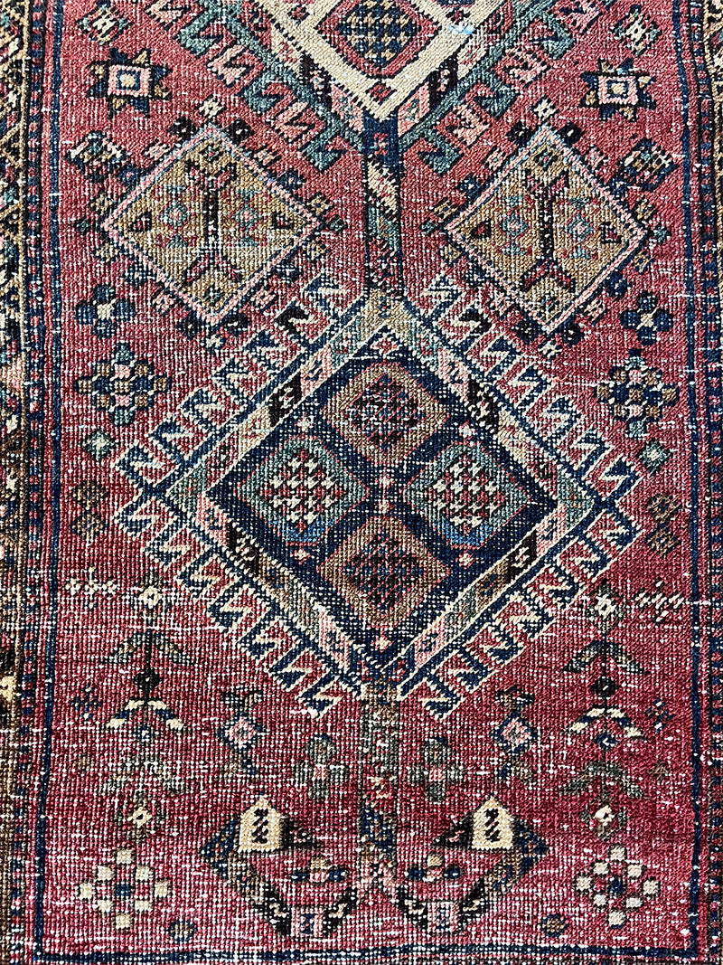 an antique heriz rug with a raspberry pink field and three pretty central medallions