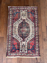 an antique hamadan rug with a pink and midnight blue palette with ivory details