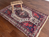 an antique hamadan rug with a pink and midnight blue palette with ivory details