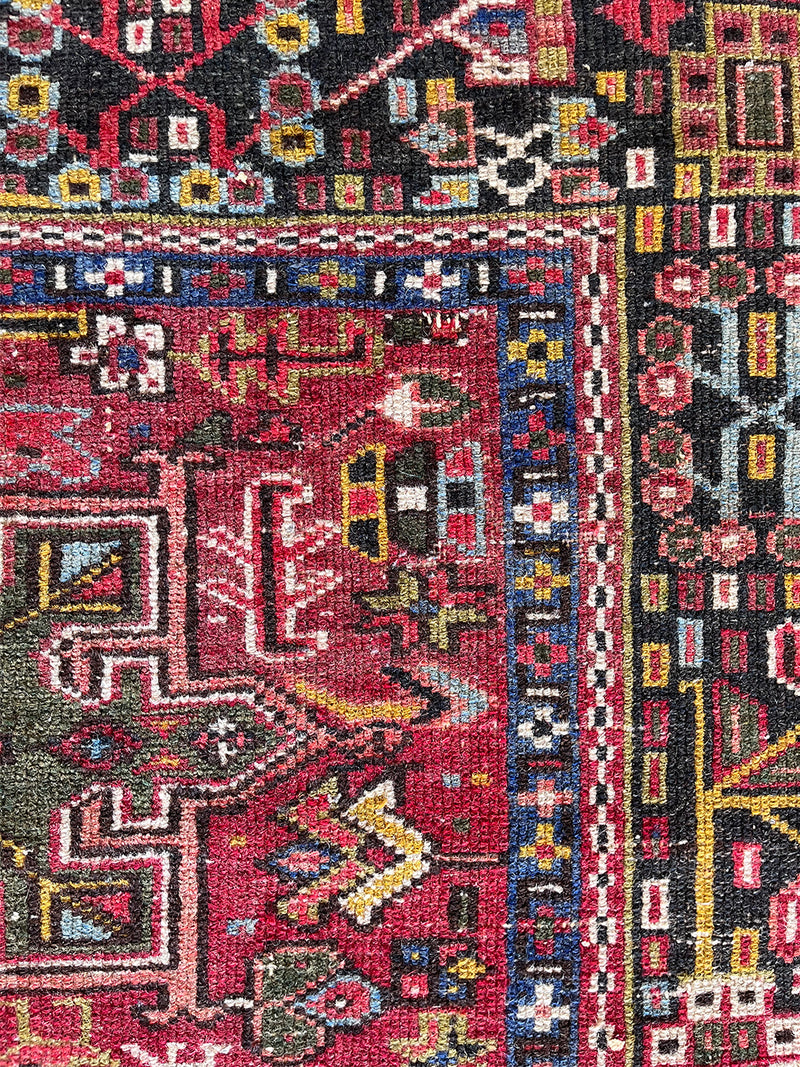 a vintage heriz karajah rug wirth a pink/red palette and bright yellow and green accents
