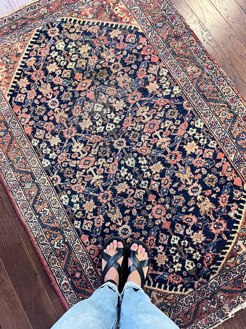 a vintage mahal rug with a dark blue field and pink floral details