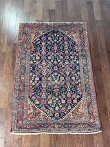 a vintage mahal rug with a dark blue field and pink floral details