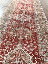 an antique heriz karajah runner with a dark coral field and icy blue and teal accents