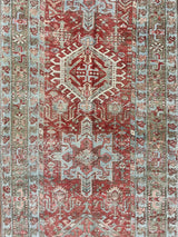 an antique heriz karajah runner with a dark coral field and icy blue and teal accents