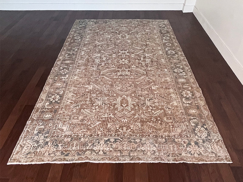 a large vintage heriz rug with brown undertones and teal accents