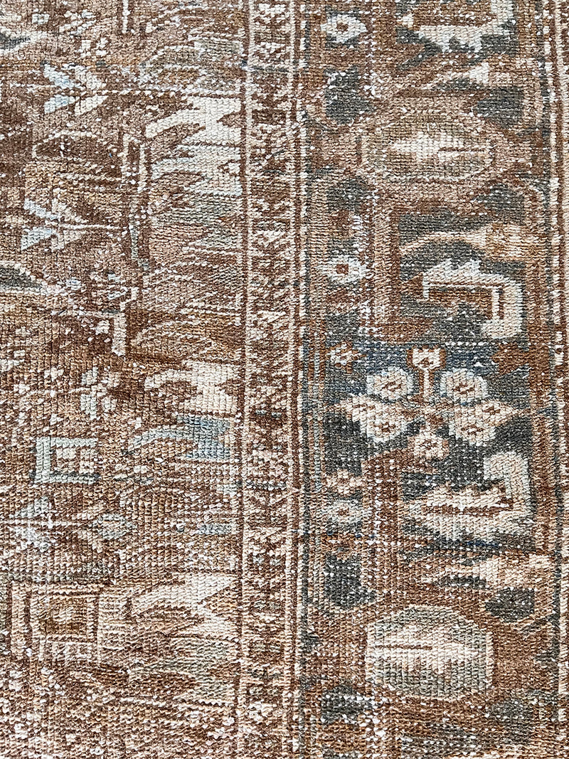 a large vintage heriz rug with brown undertones and teal accents
