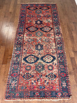 an antique sumac runner with a red field and blue, pink and green accents
