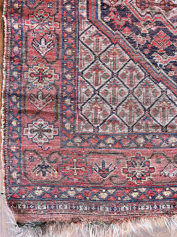 an antique qashqai rug with a red and navy blue palette