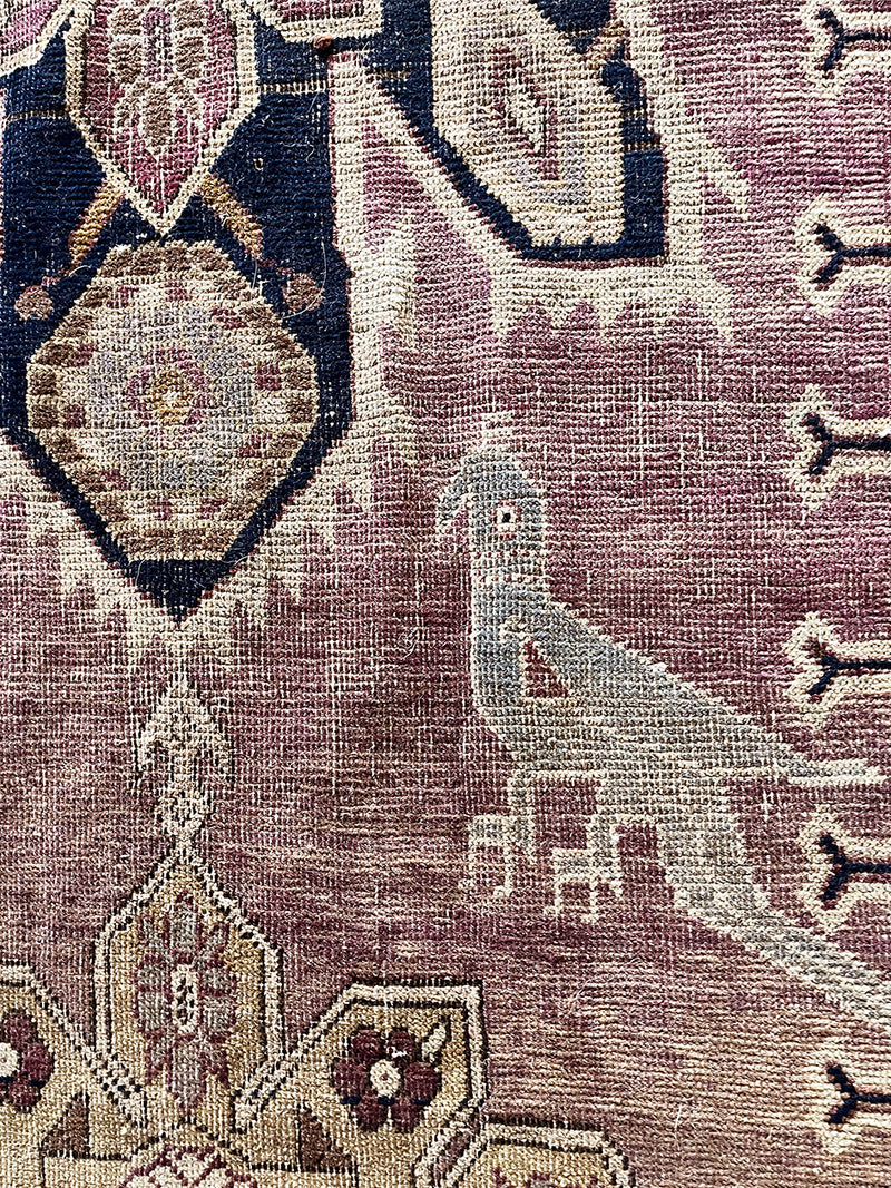 an antique caucasian karabagh runner with a lilac field and a dark blue border and medallions 