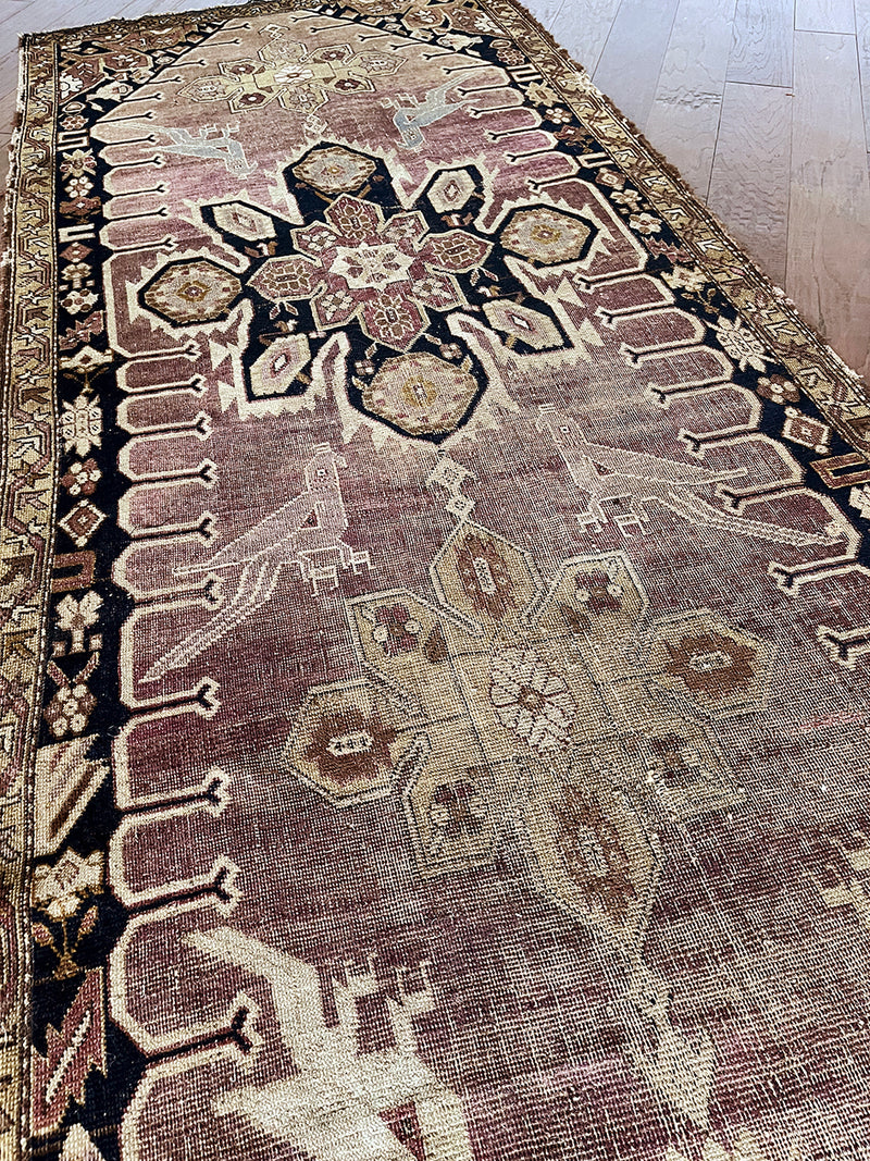 an antique caucasian karabagh runner with a lilac field and a dark blue border and medallions 