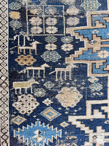 an antique caucasian rug with a blue palette and geometric pattern