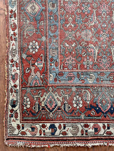 an antique kurdish rug with a brick red field and blue trellis pattern