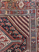 an antique qashqai rug with a pretty pin-stripe design and classic blue and red medallions