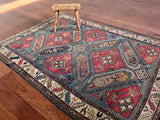 an antique kazak rug with a bright blue field and pink, coral and dark blue accents