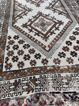 a vintage moroccan rug with a bright cream field and brown, orange and taupe accents