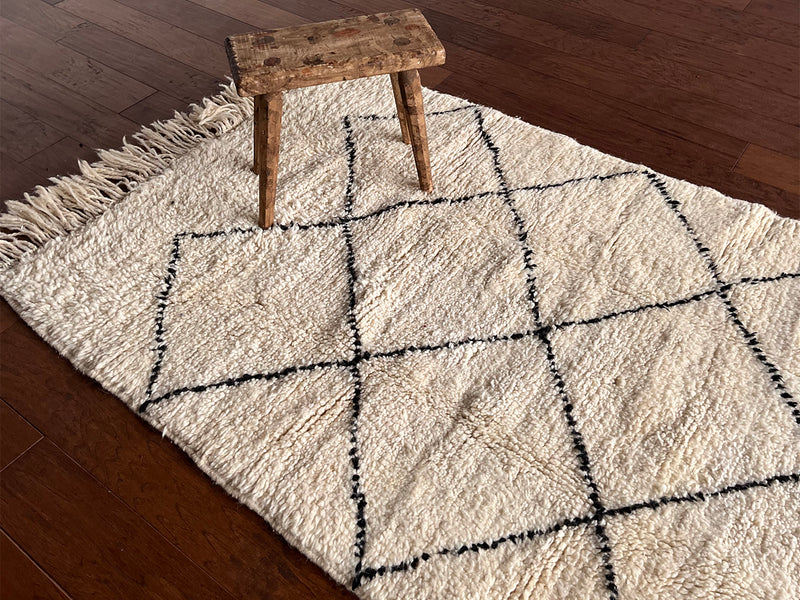 a vintage beni runner with a thick white pile and black diamond pattern