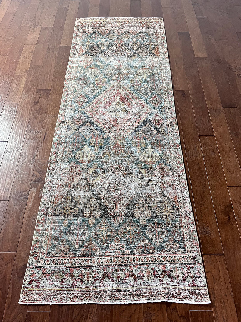 an antique chosakan runner with a faded turquoise/teal palette and terracotta accents