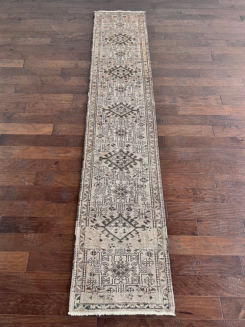 a vintage heriz runner with a taupe field and brown and teal medallions