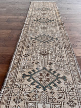 a vintage heriz runner with a taupe field and brown and teal medallions