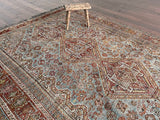 an antique shiraz rug with an icy blue field and coral medallions