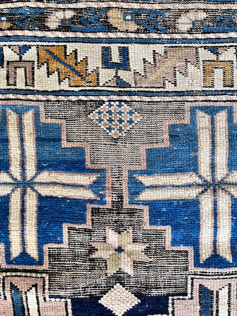 an antique caucasian rug with a blue, brown and taupe pattern