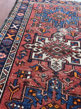 a mini vintage heriz karajah rug with a coral field and blue and white medallions